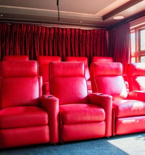 Red leather recliner chairs in a home theatre.