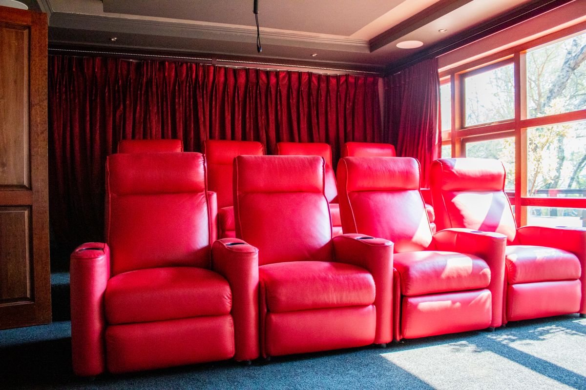 Red leather recliner chairs in a home theatre.