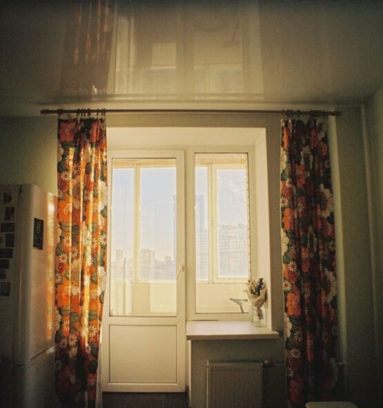 Floral patterned curtains framing a bright window.
