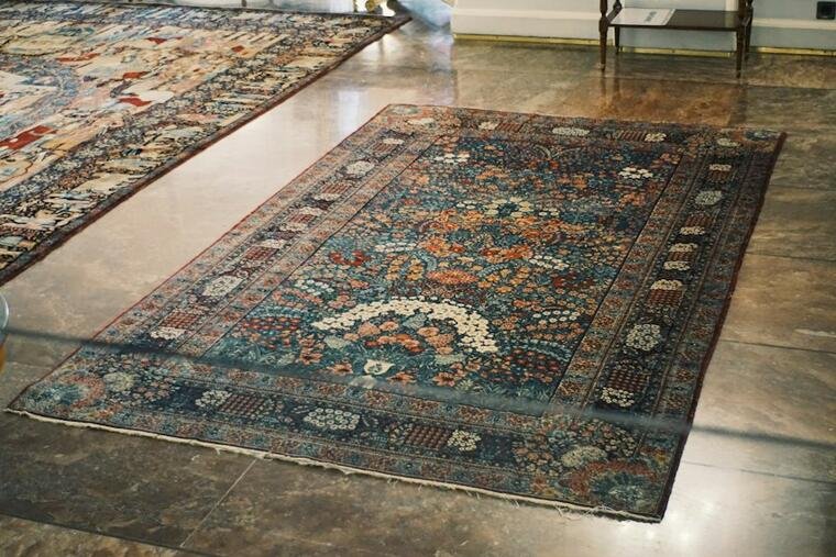 Ornate deep-toned rug with a central medallion on a polished floor.