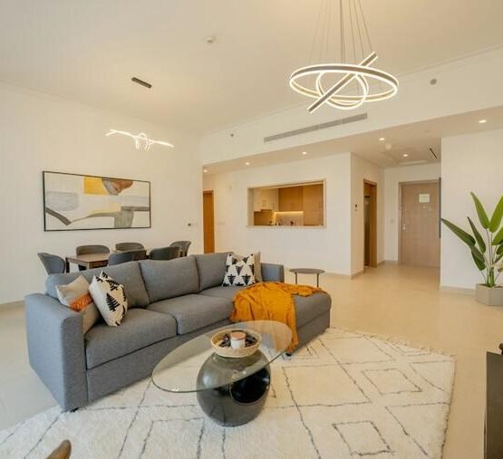 Ivory linework rug beneath a gray sofa in a bright living room.