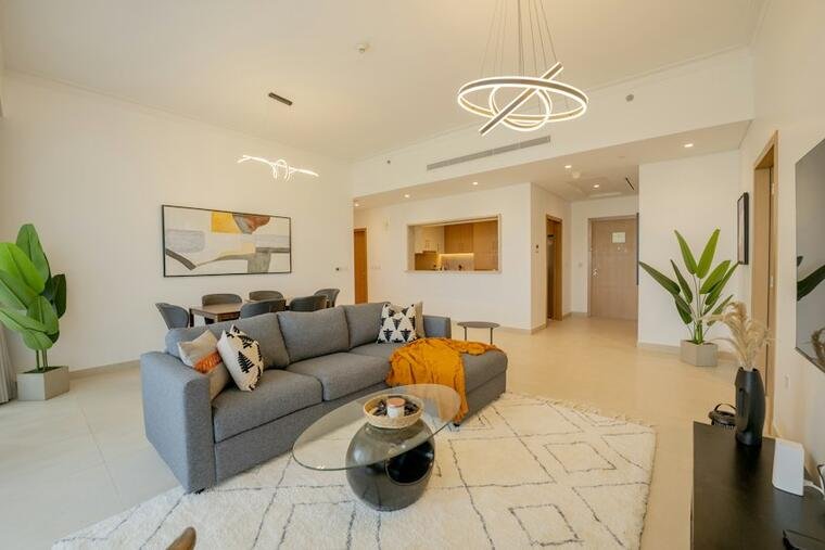 Ivory linework rug beneath a gray sofa in a bright living room.