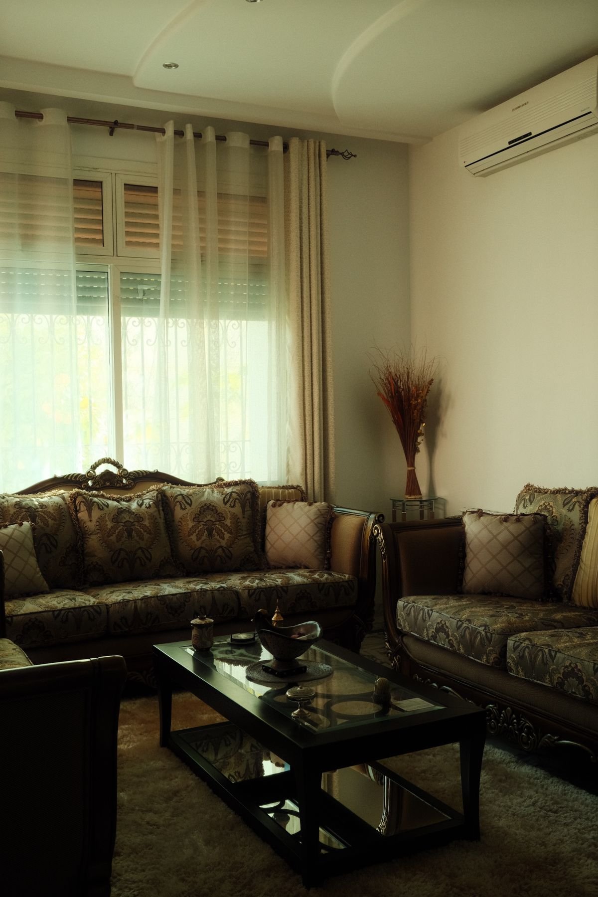 Dark tufted sofa set in a traditional living room.